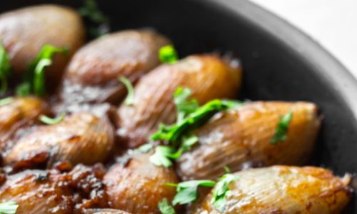 baked onions in a skillet with herbs