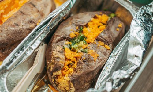 baked stuffed sweet potato in a foil tray