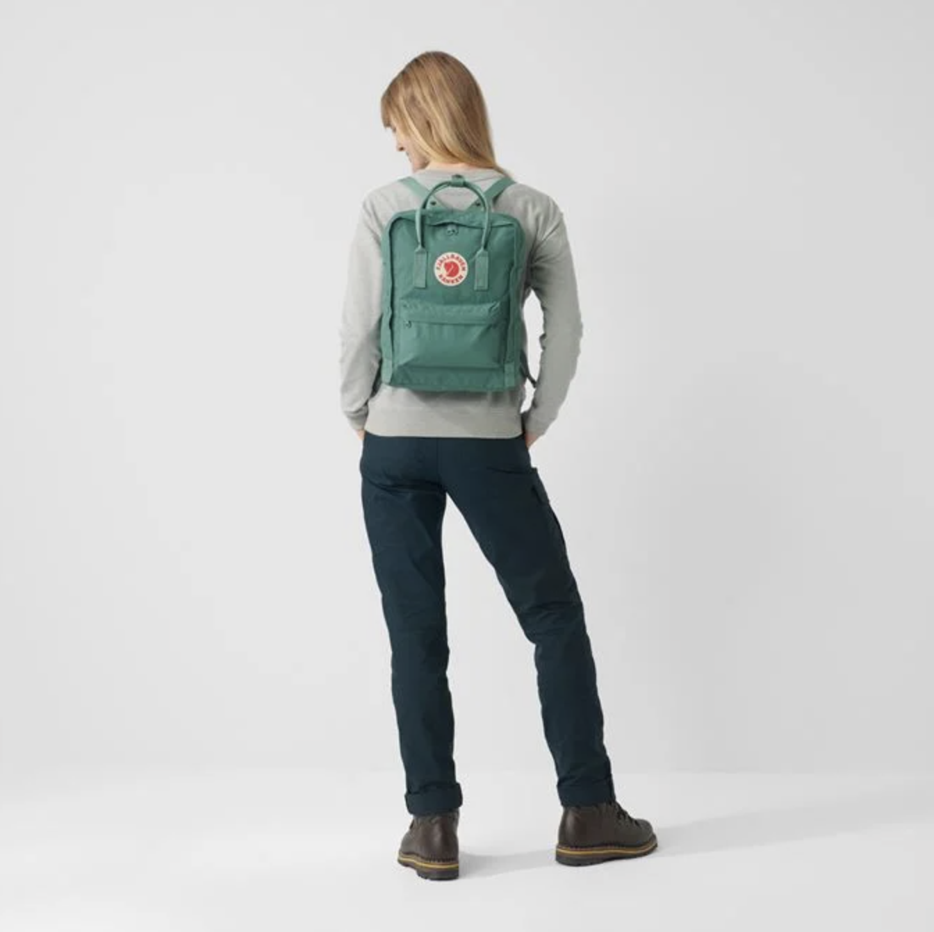 green backpack on woman - gifts for uni students
