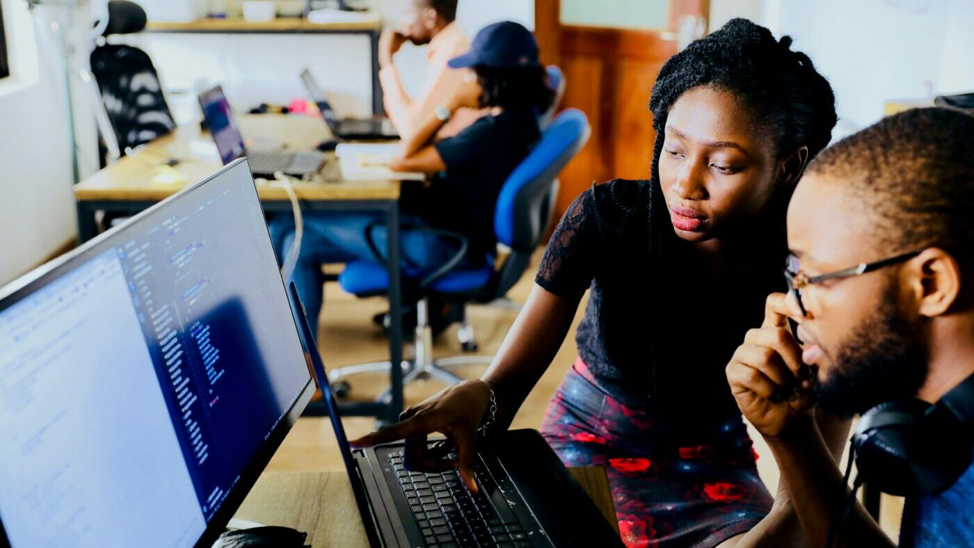 Woman helping man on computer