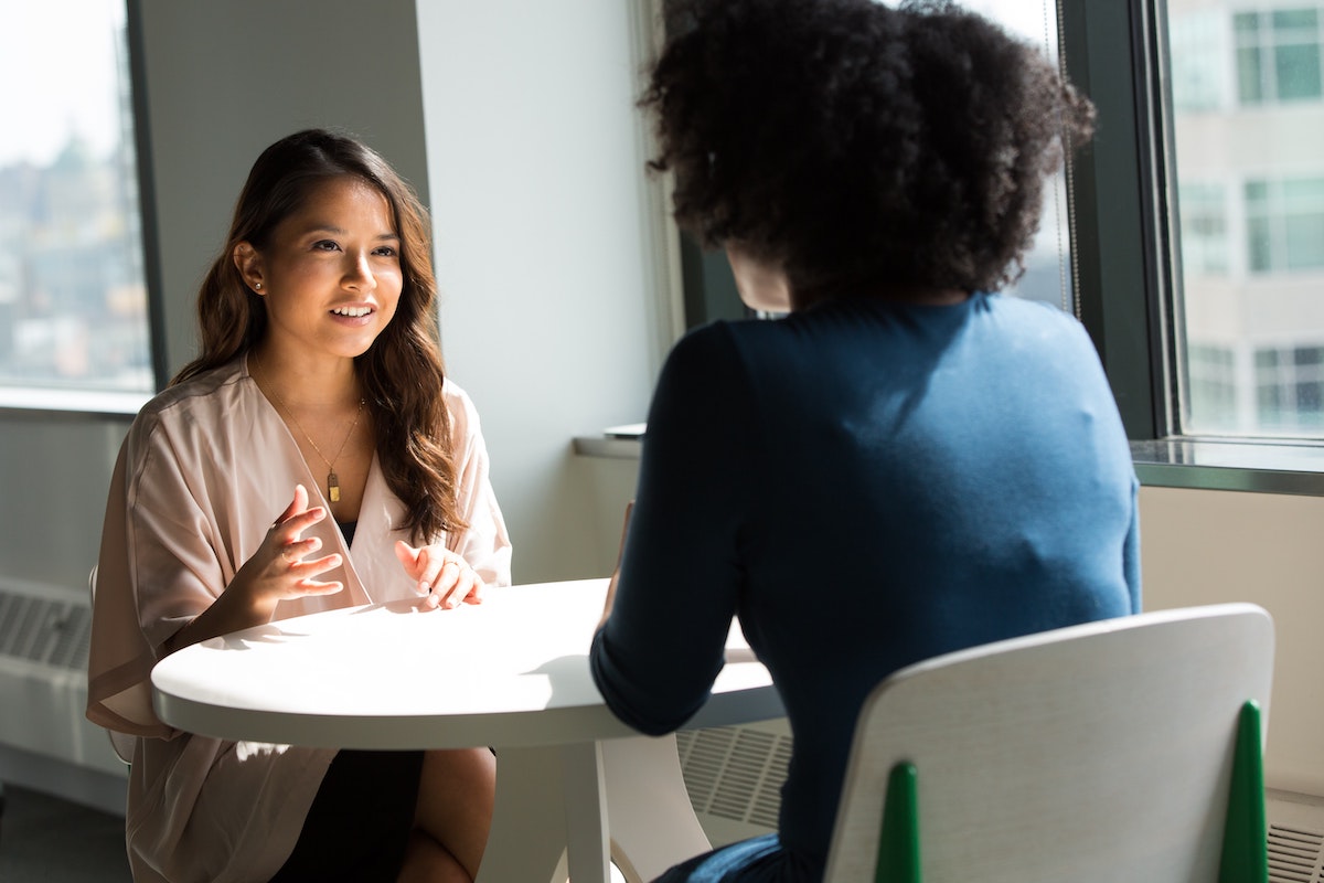 two women sat at table for interview