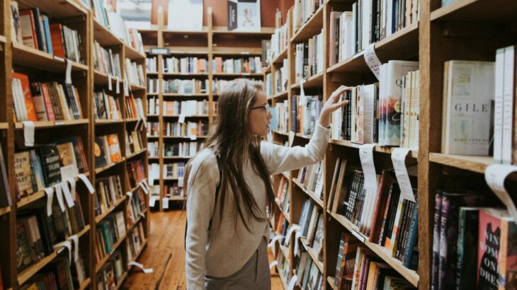 Woman browsing books in a library - student finance payment dates